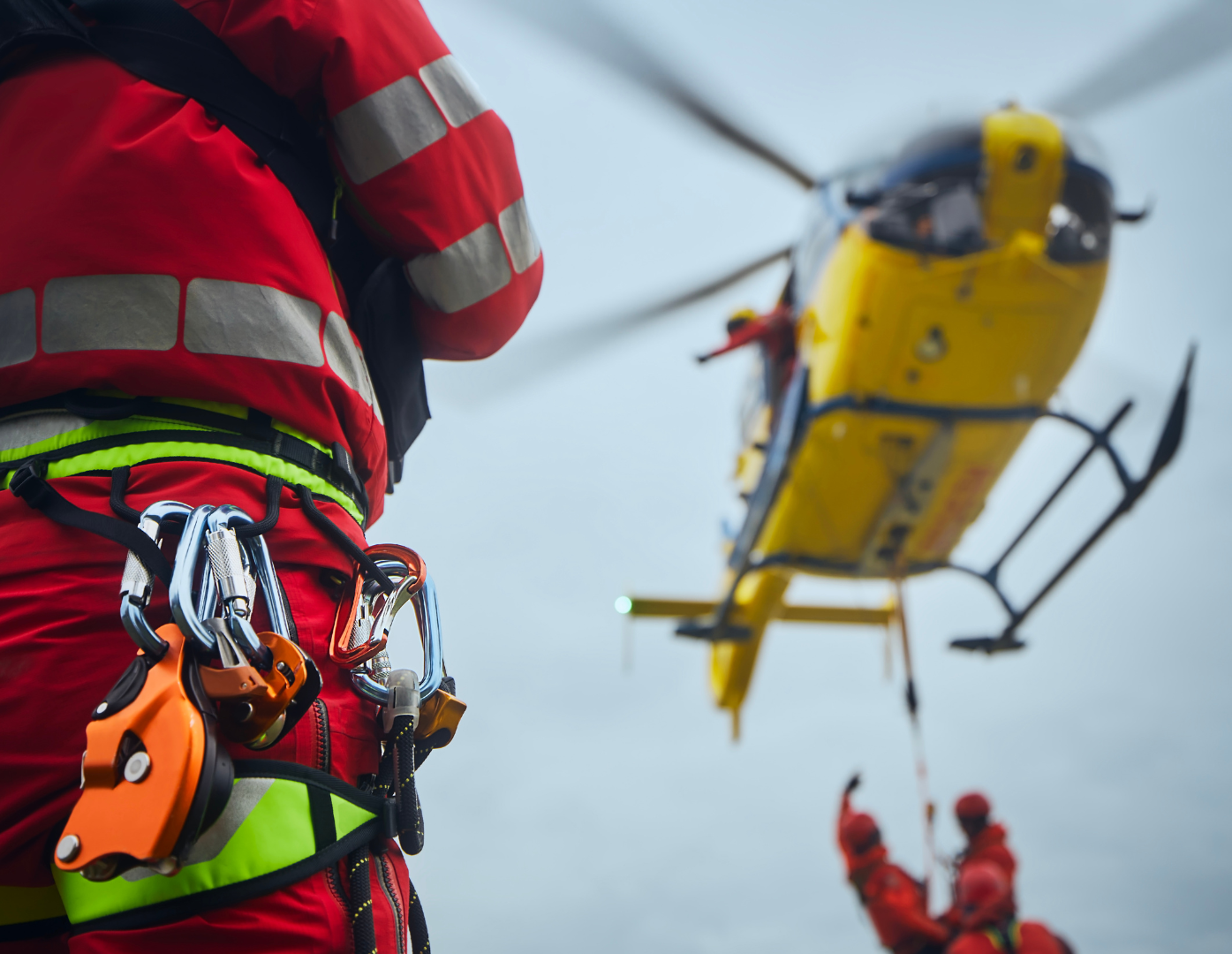 rescue man standing looking at a blurry rescue helicopter in the distance