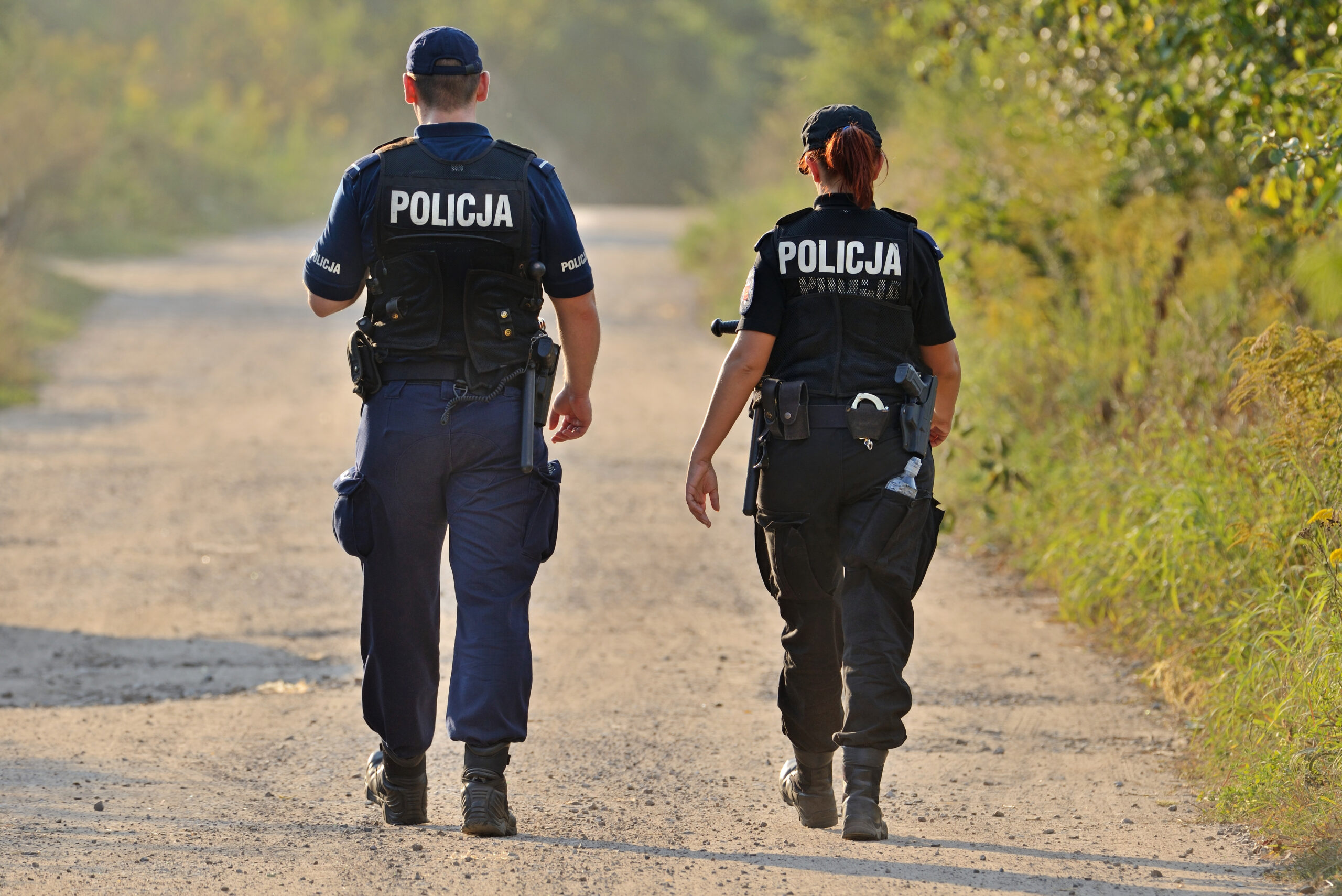 Polish police walking down a dirt road